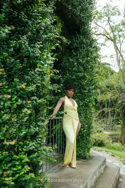 Woman in a yellow dress on stone steps with an ivy-covered arch in the Rio de Janeiro Botanical Garden