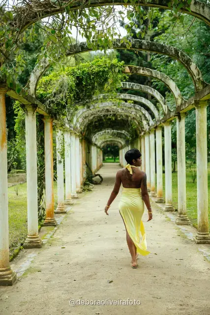 Woman in a yellow dress walking through the arched pergola at the Rio de Janeiro Botanical Garden