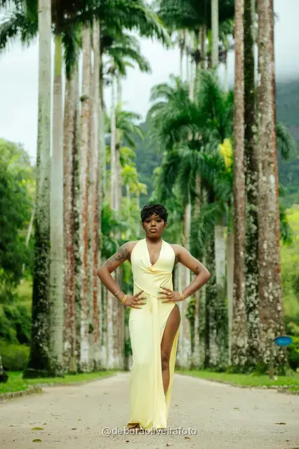 Mujer con vestido amarillo cerca de la fuente y las palmeras imperiales del Jardín Botánico de Río de Janeiro