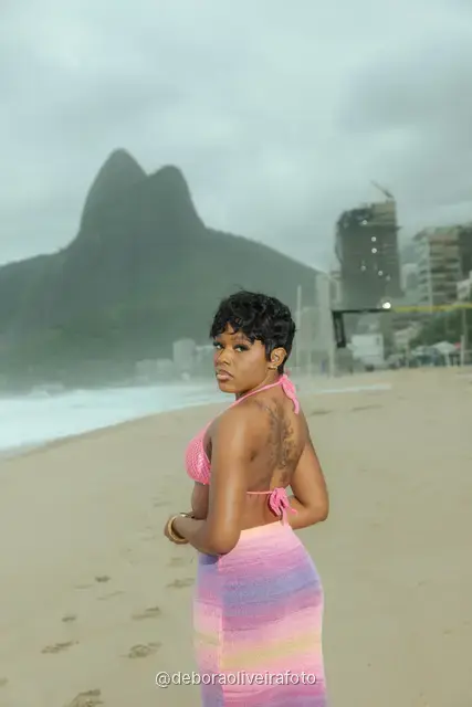 Mujer con conjunto de crochet rosa en la playa de Ipanema con el cerro Dois Irmãos detrás