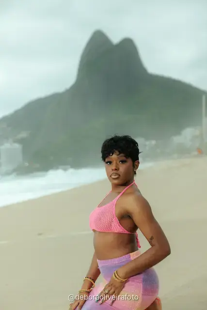 Mujer con conjunto de crochet rosa en la playa de Ipanema con el cerro Dois Irmãos detrás