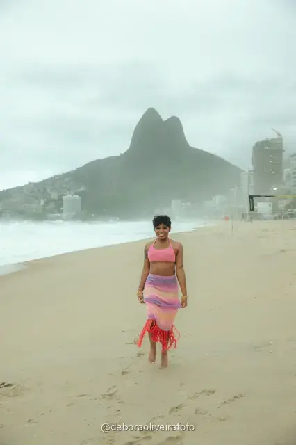 Mujer con conjunto de crochet rosa en la playa de Ipanema con el cerro Dois Irmãos detrás