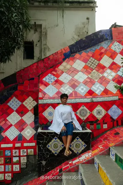 Mujer con blusa blanca y jeans en la Escalinata Selarón, en Río de Janeiro