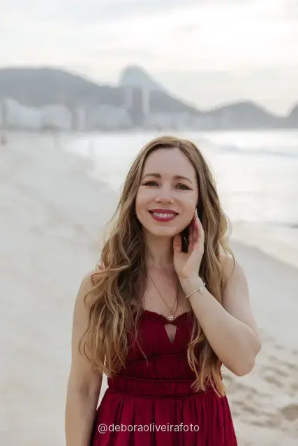 Woman in a long red dress with a scarf on Copacabana Beach in Rio de Janeiro