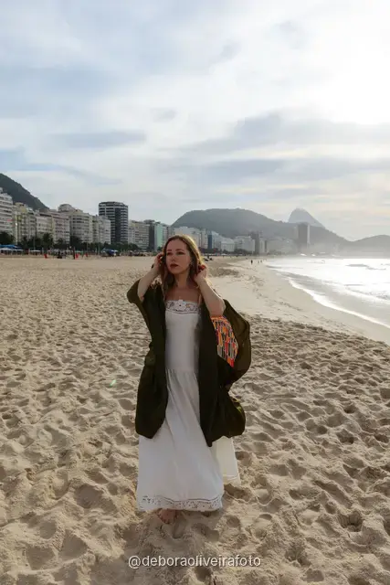 Woman in a long red dress with a scarf on Copacabana Beach in Rio de Janeiro