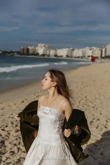 Woman in a long red dress with a scarf on Copacabana Beach in Rio de Janeiro