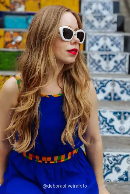 Woman in a blue dress sitting on the colorful tiled Selarón Steps in Santa Teresa, Rio de Janeiro