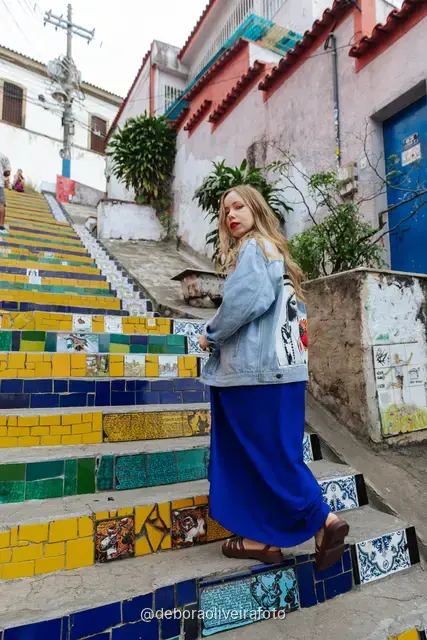 Woman in a blue dress sitting on the colorful tiled Selarón Steps in Santa Teresa, Rio de Janeiro