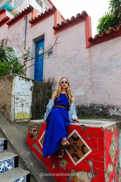 Woman in a blue dress sitting on the colorful tiled Selarón Steps in Santa Teresa, Rio de Janeiro