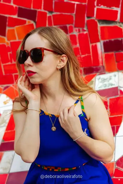 Woman in a sequin top in front of the red tile wall at the Selarón Steps, and a green coconut on a graffiti street corner