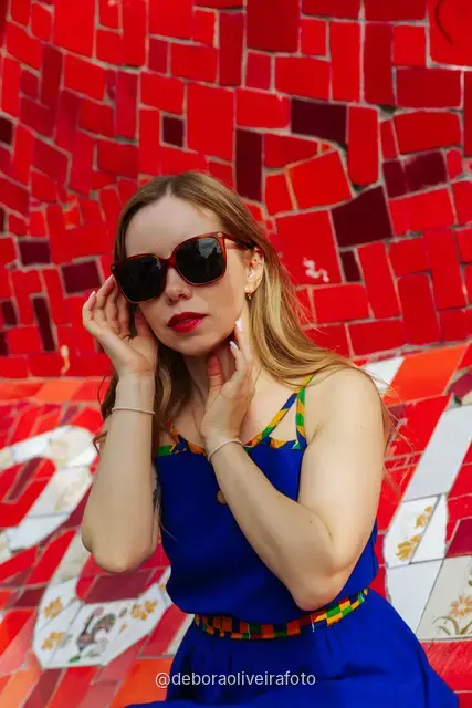 Woman in a sequin top in front of the red tile wall at the Selarón Steps, and a green coconut on a graffiti street corner