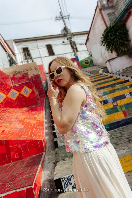Woman in a sequin top in front of the red tile wall at the Selarón Steps, and a green coconut on a graffiti street corner
