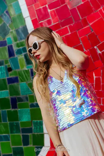Woman in a sequin top in front of the red tile wall at the Selarón Steps, and a green coconut on a graffiti street corner