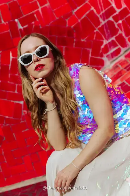 Woman in a sequin top in front of the red tile wall at the Selarón Steps, and a green coconut on a graffiti street corner