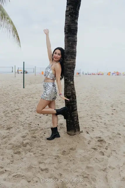 Mujer con enterizo corto de flecos rojos, sombrero y gafas rojas en la vereda de olas de Copacabana, en Río de Janeiro