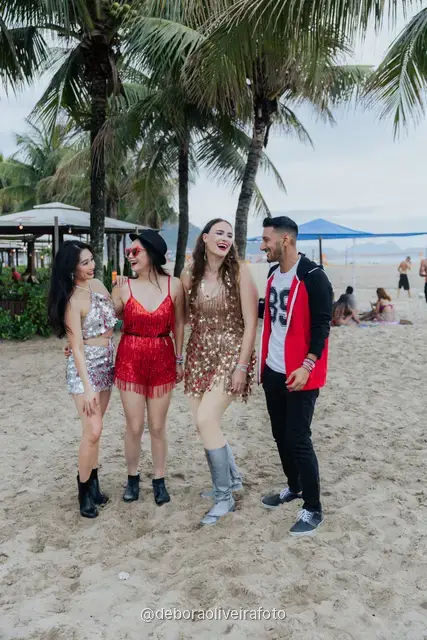 Grupo de cuatro personas con looks de lentejuelas caminando y saltando en la avenida de Copacabana, en Río de Janeiro