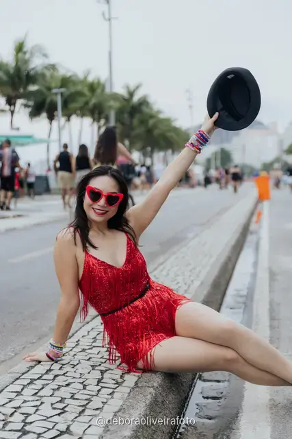 Individual portrait in a sequin outfit on the median of the avenue at Copacabana with the mountains behind