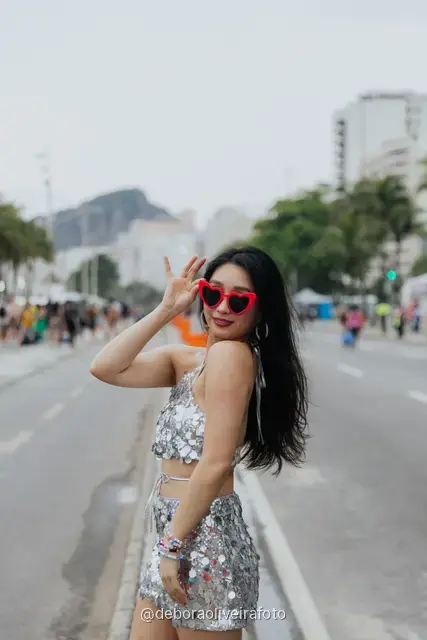 Retrato individual con look de lentejuelas en el cantero central de la avenida de Copacabana con las montañas detrás