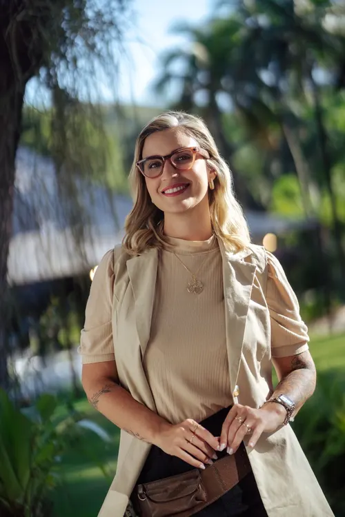 Débora Oliveira smiling in a garden in Rio de Janeiro