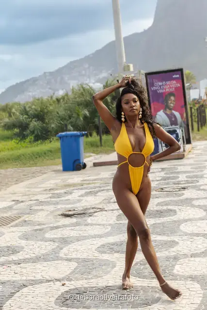 Mulher de maiô amarelo no calçadão de Ipanema com o Morro Dois Irmãos ao fundo