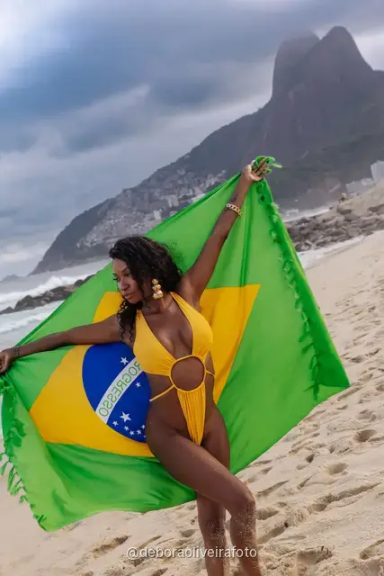 Woman holding the Brazilian flag on Ipanema Beach, Rio de Janeiro