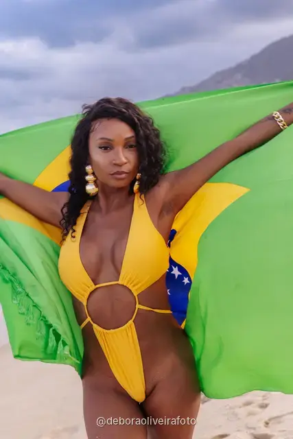 Mulher segurando a bandeira do Brasil na praia de Ipanema, no Rio de Janeiro
