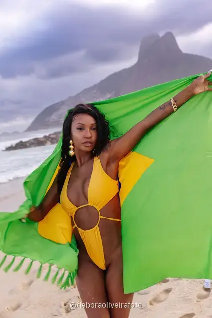 Mulher segurando a bandeira do Brasil na praia de Ipanema, no Rio de Janeiro