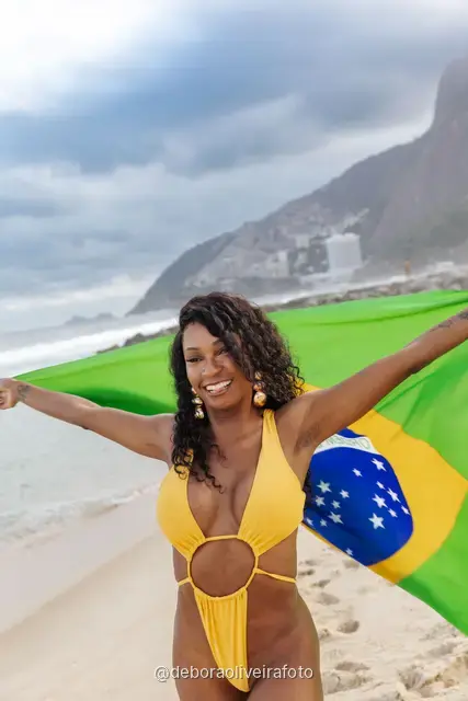 Woman holding the Brazilian flag on Ipanema Beach, Rio de Janeiro