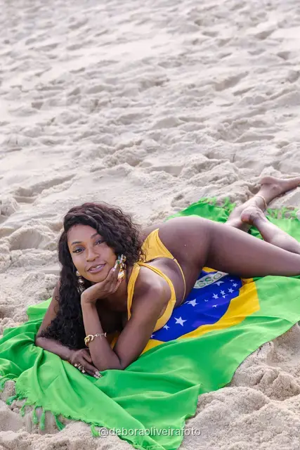 Woman holding the Brazilian flag on Ipanema Beach, Rio de Janeiro