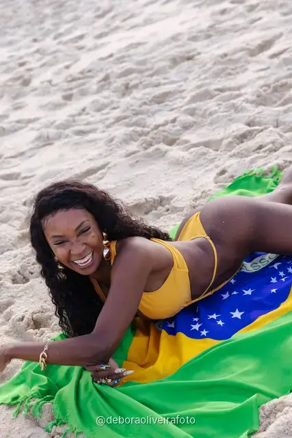Mulher segurando a bandeira do Brasil na praia de Ipanema, no Rio de Janeiro