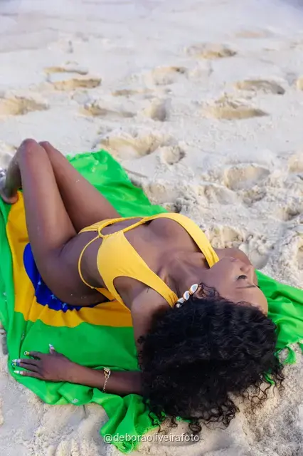 Woman holding the Brazilian flag on Ipanema Beach, Rio de Janeiro