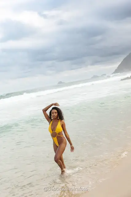 Woman in a yellow swimsuit playing in the waves at Ipanema Beach