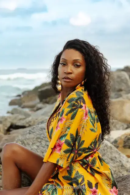 Mulher de conjunto de praia amarelo estampado nas pedras da praia de Ipanema