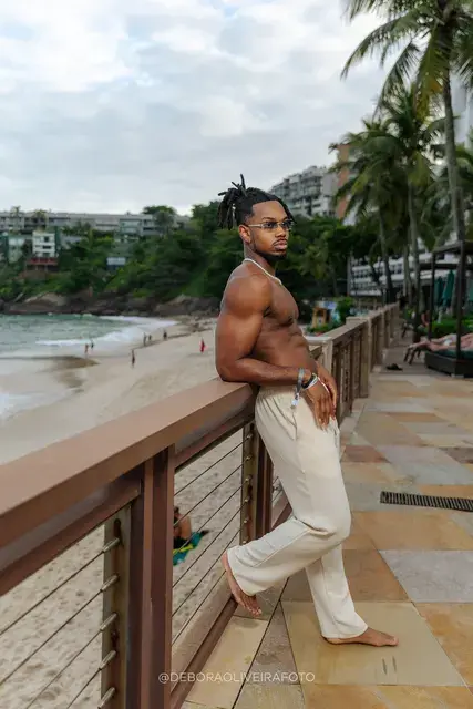Homem de calça de linho clara no deck e na areia de um hotel de frente para o mar no Rio de Janeiro