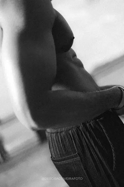 Retrato em preto e branco de detalhe de um homem de calça preta e colar de pérolas no Rio de Janeiro