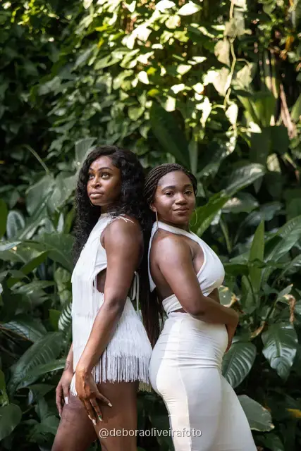 Two women in white among big leaves, forest steps and a ruined stone arch at Parque Lage