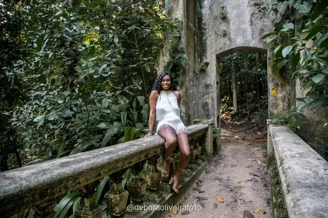 Two women in white among big leaves, forest steps and a ruined stone arch at Parque Lage