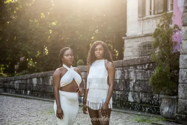 Two women in white in the garden in front of the Parque Lage mansion with the mountain behind