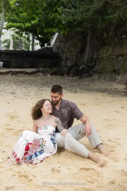 Pareja sentada junta en la arena de Praia Vermelha, en Río de Janeiro