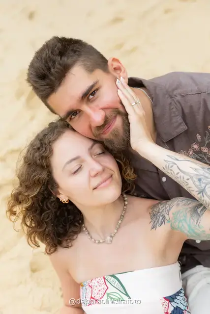 Pareja sentada junta en la arena de Praia Vermelha, en Río de Janeiro