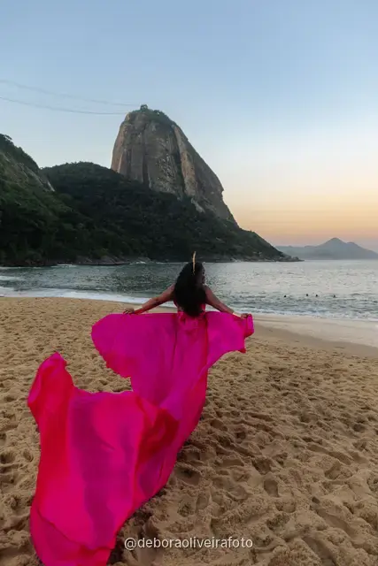 Pink flying dress caught in the wind on the sand at Praia Vermelha, Rio de Janeiro