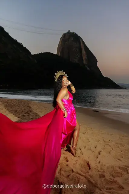 Long pink dress train spreading across the sand at Praia Vermelha at dusk