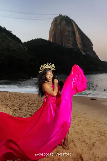 Long pink dress train spreading across the sand at Praia Vermelha at dusk