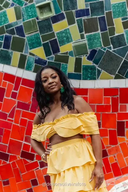 Woman in a yellow ruffled outfit on the colorful Selarón Steps in Rio de Janeiro