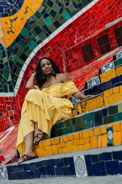 Woman in a yellow ruffled outfit on the colorful Selarón Steps in Rio de Janeiro