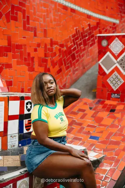 Mujer con ropa amarilla y verde de Brasil en la Escalinata Selarón, en Santa Teresa, Río de Janeiro