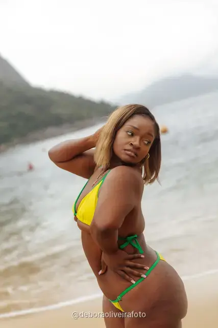 Woman in yellow and green at Praia Vermelha with Sugarloaf Mountain behind, Rio de Janeiro