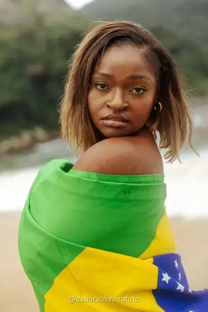 Woman in yellow and green at Praia Vermelha with Sugarloaf Mountain behind, Rio de Janeiro