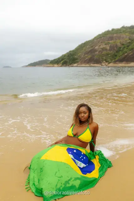 Mujer de amarillo y verde en Praia Vermelha con el Pan de Azúcar detrás, en Río de Janeiro
