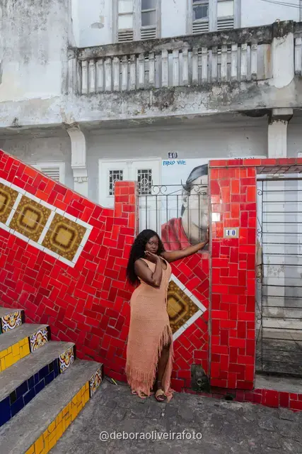 Mujer con vestido largo de crochet durazno sentada en la Escalinata Selarón de colores, en Río de Janeiro